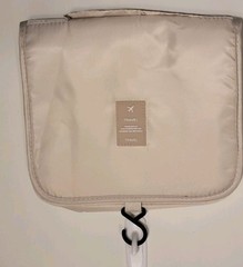 Beige Travel hanging toiletry bag designed to organize personal care items.
